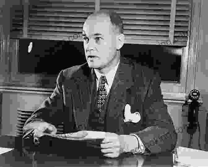 Black And White Photograph Of George Kennan Sitting At His Desk With A Serious Expression On His Face. He Is Wearing A Dark Suit And Tie And Has A Pen In His Hand. George Kennan And The Dilemmas Of US Foreign Policy